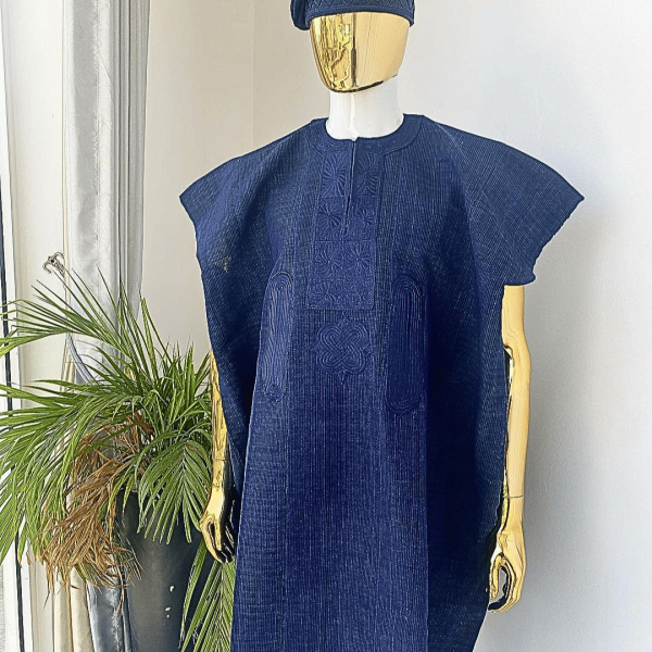 A navy blue aso oke dashiki with a floral and box-shaped embroidery design and hand-embroidered Yoruba hat